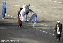 Excution publique d'une femme dans le stade de Kaboul, en 1999. Cliquez pour visionner le film.